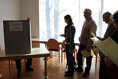 Im Wahlraum im Gemeindezentrum Kornelimünster stehen die Wahlberechtigten nach dem Gottesdienst Schlange