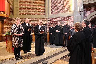 In ihrer Pfarrstelle begrüßten auch Pfarrer Armin Drack (am Mikrofon) und Pfarrerin Sylvia Engels (im Hintergrund rechts neben Pfr. Drack), die beide ebenfalls in Aachen-Mitte tätig sind, Bärbel und Joachim Büssow