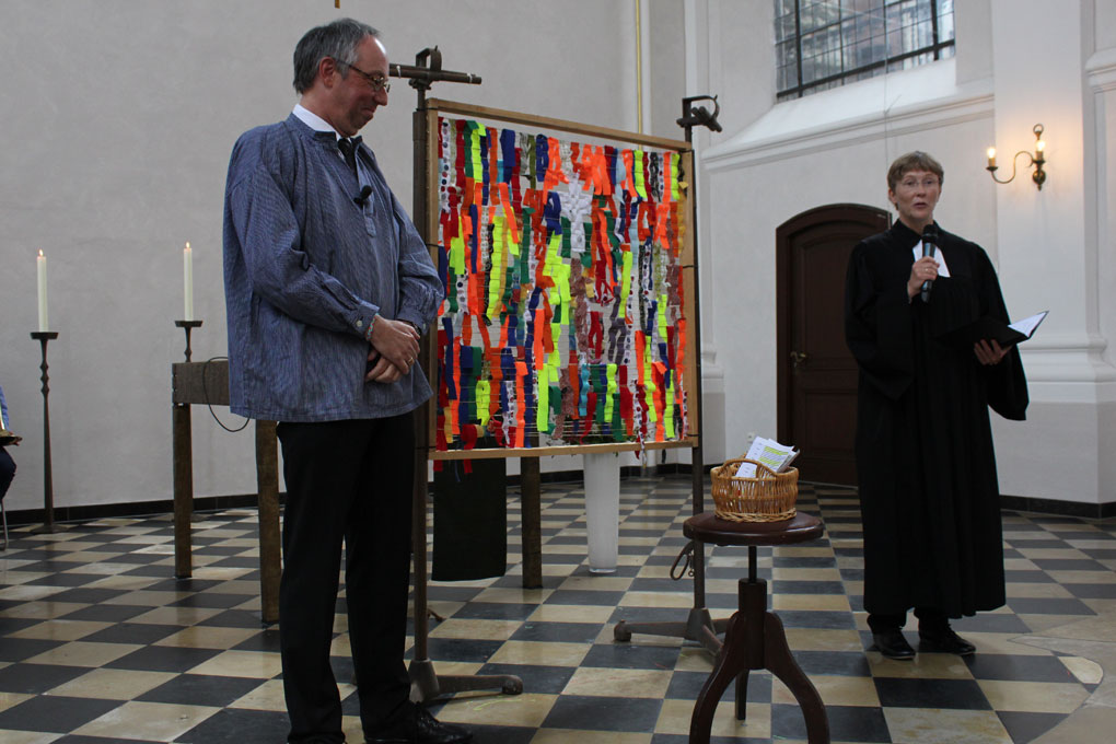 Pfarrer und Pfarrerin Joachim und Bärbel Büssow mit dem von allen Anwesenden gemeinsam verflochtenen Webrahmen.